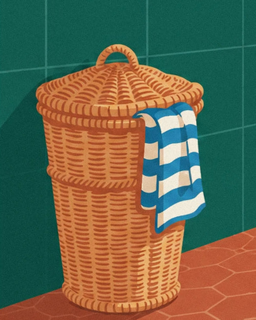 Il cesto in vimini con il suo coperchio e l'asciugamano a righe blu e bianche