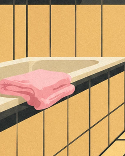 Des serviettes roses pliées sur le rebord d'une baignoire au carrelage jaune