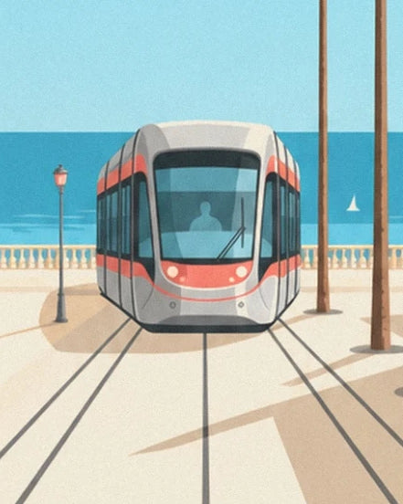 Le tramway gris et rouge sur ses rails, face à la mer et à un voilier blanc