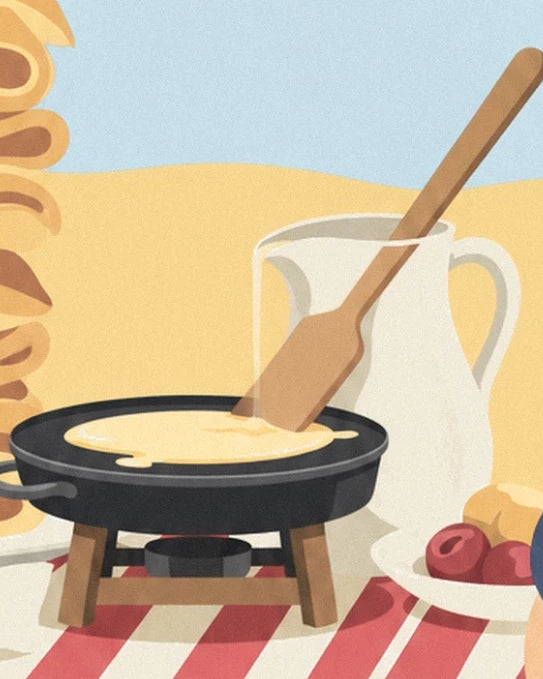 La padella nera per crêpes, la sua spatola di legno e la brocca bianca sulla tovaglia a righe