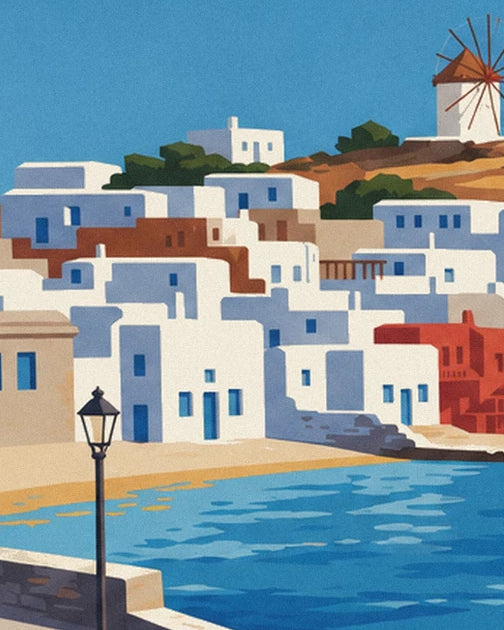 Un réverbère sur le quai, les maisons blanches et rouges et un moulin face à l’eau bleue