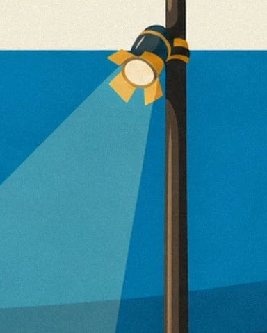 The spotlight with yellow flaps and its pale beam beside the dark post