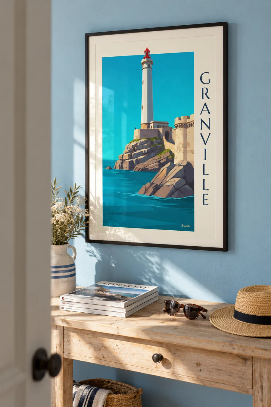 White lighthouse poster with a red lantern on the rocks of Granville: framed on the wall