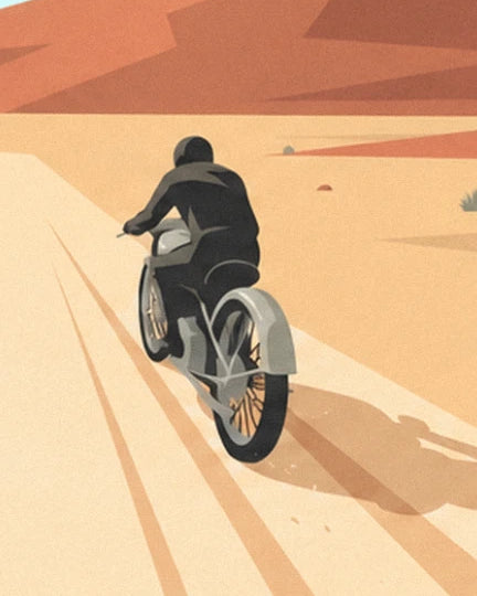 The motorcyclist in a dark jacket seen from behind, with tyre tracks in the golden sand