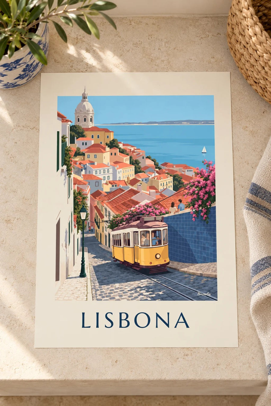 Poster tram giallo in una strada acciottolata di Lisbona di fronte al Tago: appoggiato su un tavolo
