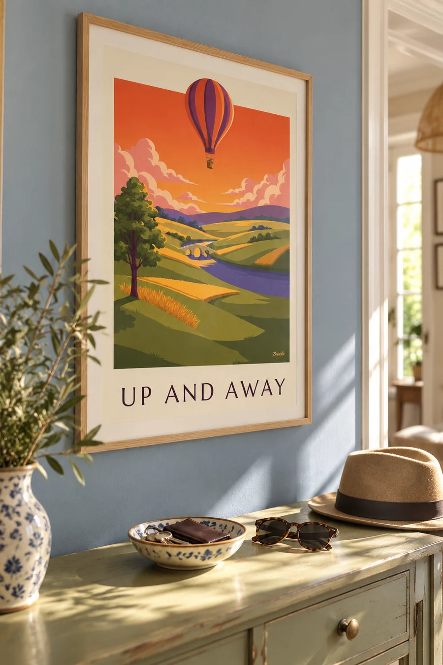 Poster of a striped hot air balloon above fields at sunset: framed on the wall