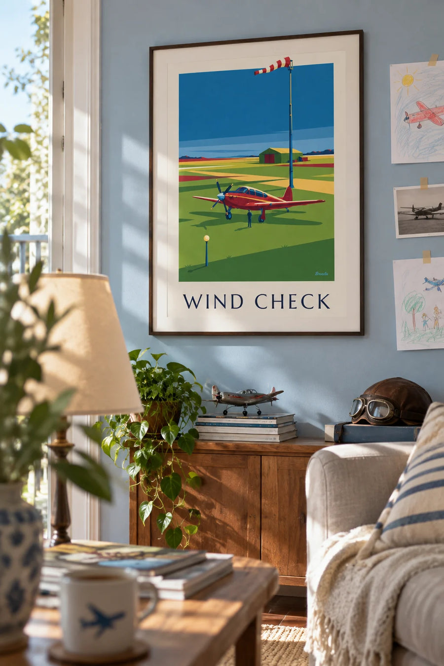 Poster of a windsock and airplane at an airfield: framed on the wall