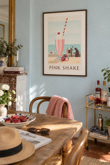 Poster of a strawberry milkshake at a diner counter: framed on the wall
