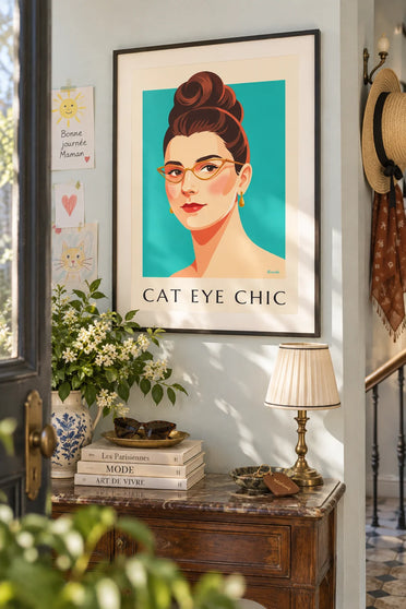 Poster of a woman’s portrait with cat-eye glasses and red lips: framed on the wall
